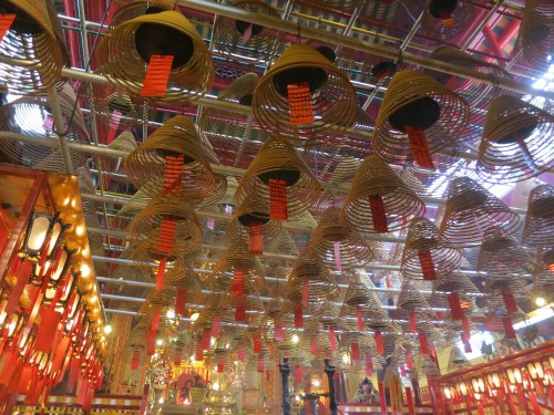 The aromatic smoke from the many incense coils hangs heavy in the air