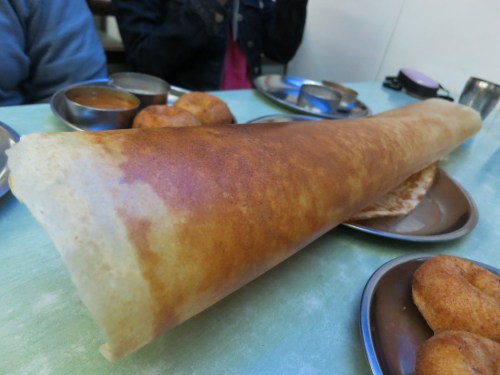 Dosa, a thin, pancake/crepe-like creation made from a batter of rice flower and lentils that can be stuffed with a variety of fillings.  To eat these behemoths (and this isn't even the biggest one available), simply crack off a few shards of the crispy exterior and use them to scoop up the stuffing