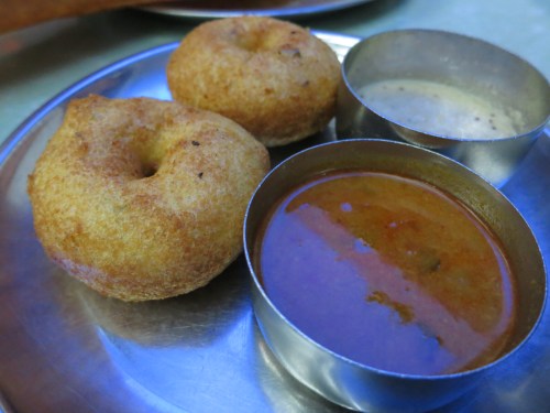 Lentil Doughnuts known as Vada served with a spicy sambar soup and a coconut chutney