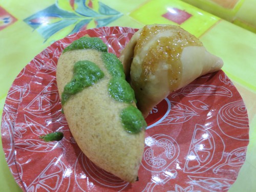 A Mirchi Vada (deep-fried, stuffed green chilies) on the left, and the ever-present Samosa (fried pouch of veggies and spices in a triangular shape) on the right