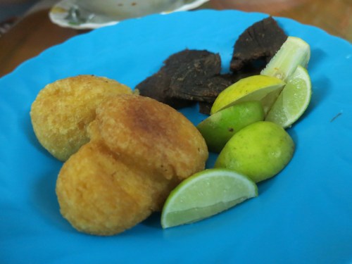 Various Chin snacks, such as dried beef jerky, doughy bean puffs, and a handful of limes