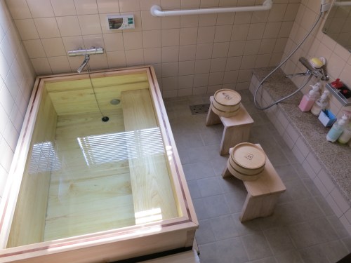 An example of a Japanese style bath (I particularly like the matching cedar wood tub, stools, and buckets).  The proper etiquette is to use the stool, bucket, and facet to first wash yourself off thoroughly.  Once you’ve rinsed off all of the soap, you can then move to the tub to soak for a while.  Although in this example, the bath is only meant for one at a time, the bath water will still be left untouched (thus the no soap in the tub rule), as it will be used by anyone else looking to soak in the tub that night.  This may seem odd to Westerners at first, but just think of it like you would a hot tub or Jacuzzi – and of course they change the water each day.