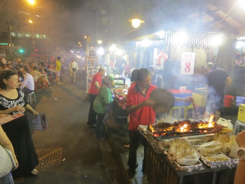 The smoky haze created by a line of Satay vendors all delicately fanning their flames